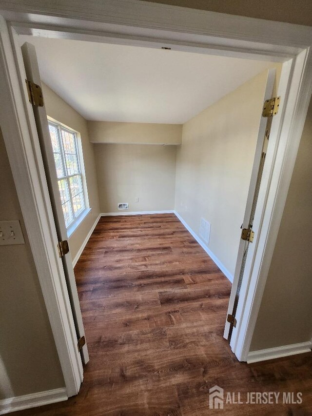 unfurnished room featuring dark wood-type flooring