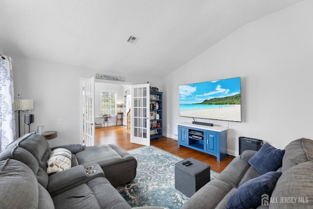 living area featuring french doors, dark wood-style flooring, visible vents, vaulted ceiling, and baseboards