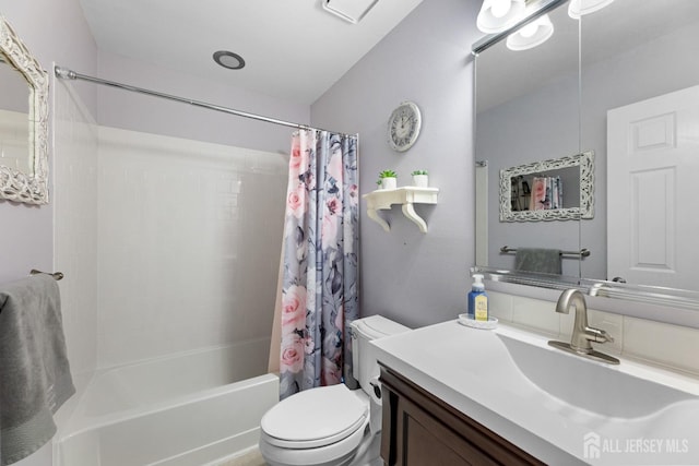 bathroom with vanity, shower / bath combo with shower curtain, and toilet