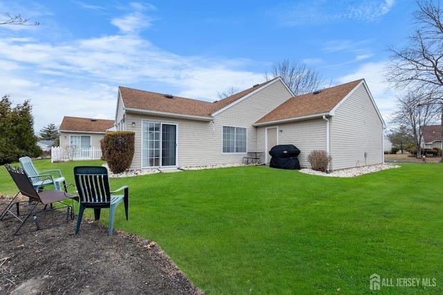 rear view of property with a lawn