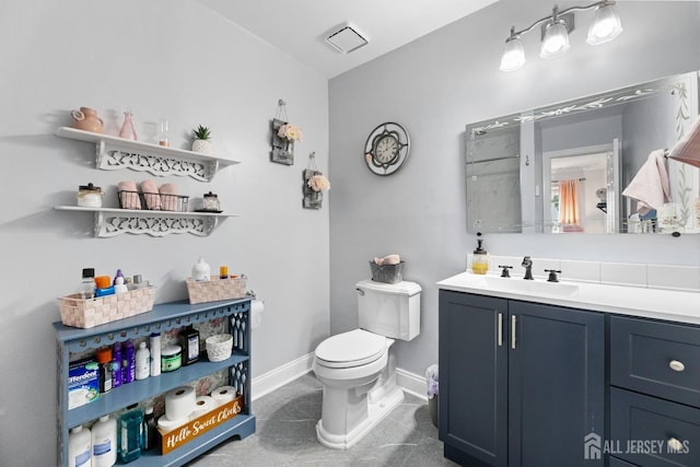 bathroom featuring baseboards, vanity, and toilet