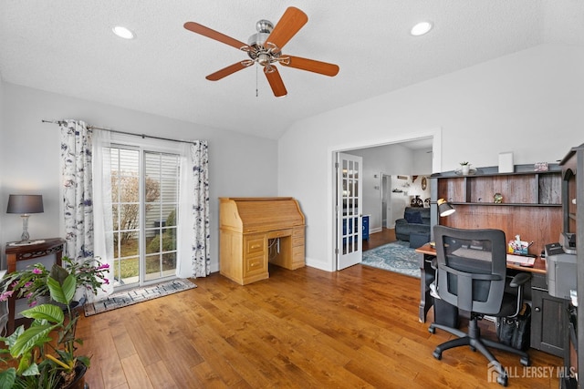 office space with ceiling fan, a textured ceiling, vaulted ceiling, and hardwood / wood-style floors