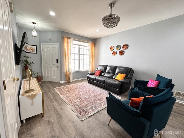 living room with recessed lighting, wood finished floors, visible vents, and baseboards