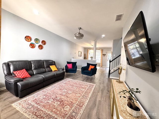 living area featuring baseboards, visible vents, stairway, light wood-type flooring, and recessed lighting