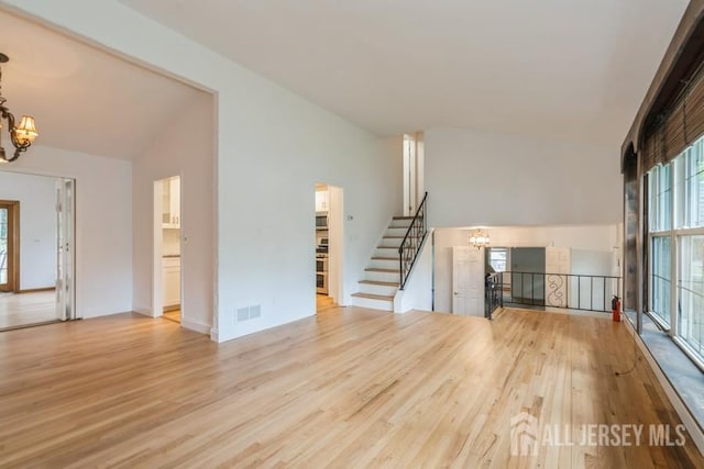 42 Corona Rd, East Brunswick, NJ 08816 - unfurnished living room with a chandelier, lofted ceiling, and wood finished floors