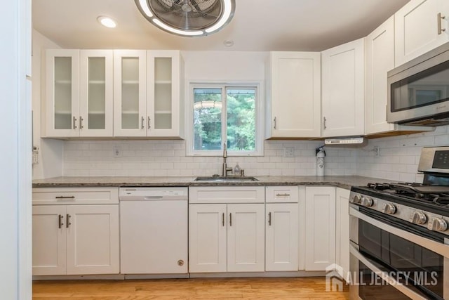 42 Corona Rd, East Brunswick, NJ 08816 - kitchen with appliances with stainless steel finishes, dark stone counters, white cabinetry, tasteful backsplash, and recessed lighting