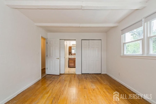 42 Corona Rd, East Brunswick, NJ 08816 - unfurnished bedroom with light wood-type flooring, beam ceiling, a closet, and connected bathroom