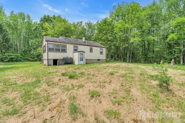 211 E Greystone Rd, Old Bridge, NJ 08857 - back of property with oil tank, a lawn, and a wooded view