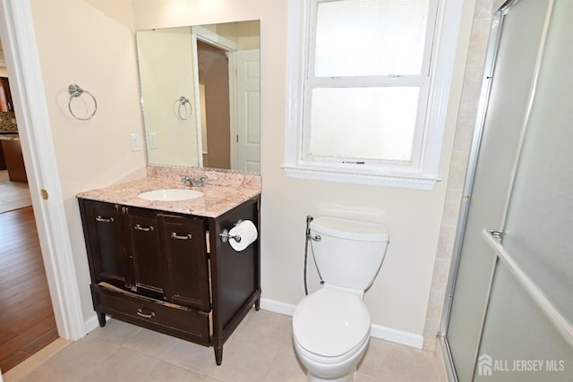 bathroom with vanity, tile patterned floors, a shower with door, and toilet