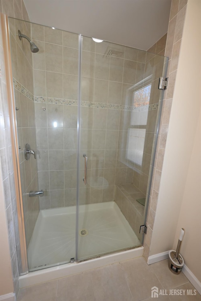 bathroom featuring a shower with shower door and tile patterned flooring