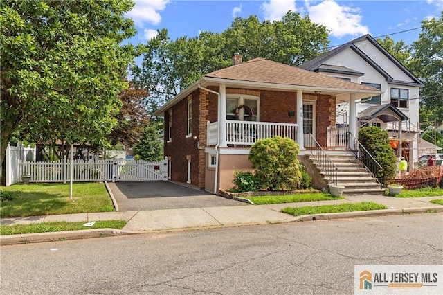 28 Wildwood Ave, Fords, NJ 08863 - view of front facade featuring a gate, brick siding, asphalt driveway, covered porch, and a chimney