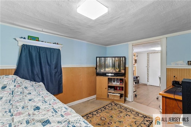 28 Wildwood Ave, Fords, NJ 08863 - bedroom featuring a textured ceiling, wainscoting, and wooden walls