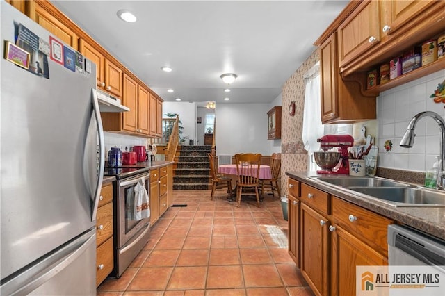 28 Wildwood Ave, Fords, NJ 08863 - kitchen with stainless steel appliances, under cabinet range hood, tasteful backsplash, brown cabinetry, and recessed lighting