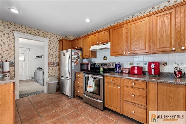 28 Wildwood Ave, Fords, NJ 08863 - kitchen featuring appliances with stainless steel finishes, under cabinet range hood, wallpapered walls, brown cabinets, and dark countertops