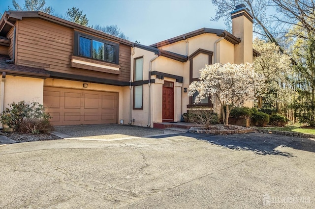 441 Sayre Dr, Plainsboro, NJ 08540 - view of front facade featuring asphalt driveway, a chimney, stucco siding, and an attached garage