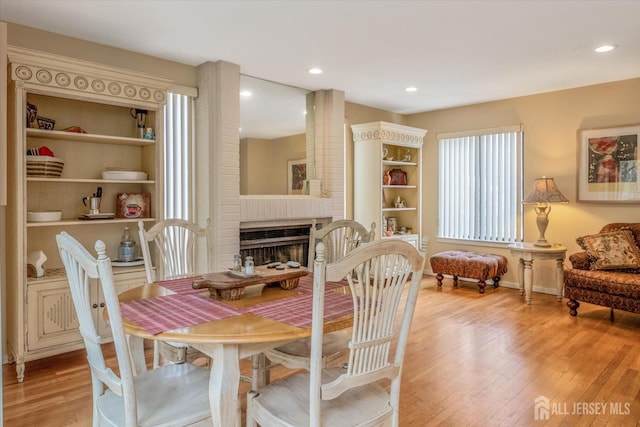 441 Sayre Dr, Plainsboro, NJ 08540 - dining space with light wood-style floors, a brick fireplace, and recessed lighting