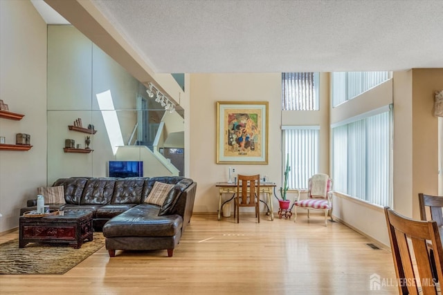 441 Sayre Dr, Plainsboro, NJ 08540 - living area with healthy amount of natural light, wood finished floors, and a textured ceiling