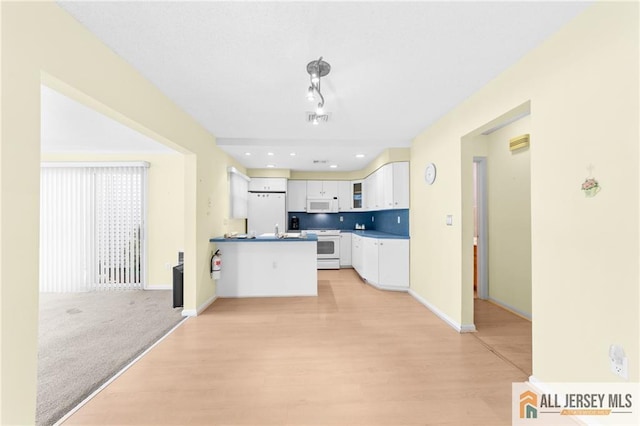 703 Croydon Rd Unit 703B, Monroe, NJ 08831 - kitchen featuring white appliances, white cabinets, a peninsula, and light wood-style floors