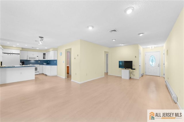 703 Croydon Rd Unit 703B, Monroe, NJ 08831 - unfurnished living room featuring a baseboard radiator, light wood finished floors, and recessed lighting