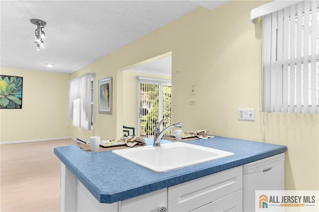 703 Croydon Rd Unit 703B, Monroe, NJ 08831 - kitchen featuring white dishwasher, white cabinetry, light wood-type flooring, dark countertops, and a textured ceiling