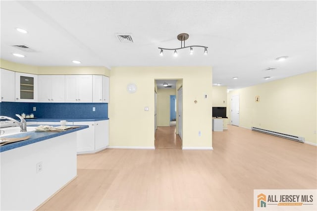 703 Croydon Rd Unit 703B, Monroe, NJ 08831 - kitchen featuring a baseboard heating unit, light wood finished floors, white cabinetry, glass insert cabinets, and recessed lighting