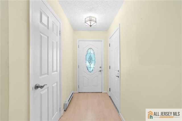 703 Croydon Rd Unit 703B, Monroe, NJ 08831 - entryway featuring baseboard heating, a textured ceiling, and light wood-style floors