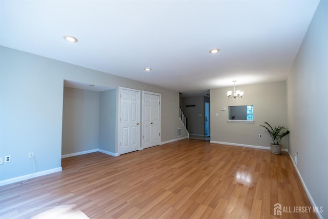72 Morgan Pl E, Brunswick, NJ 08816 - unfurnished living room featuring a chandelier, light wood-type flooring, recessed lighting, and stairs