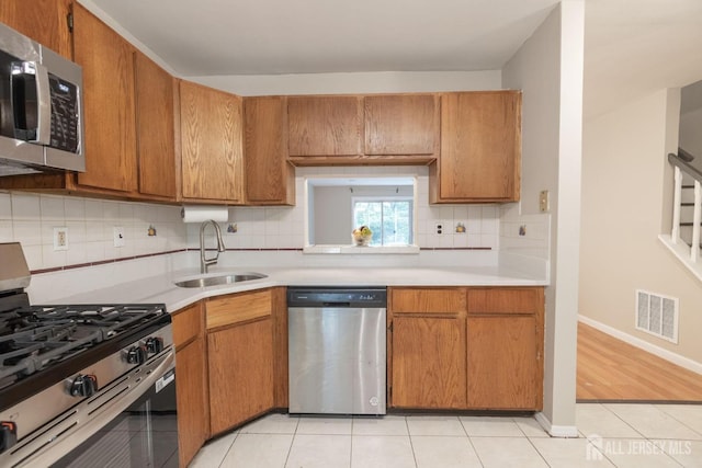 72 Morgan Pl E, Brunswick, NJ 08816 - kitchen featuring appliances with stainless steel finishes, light countertops, light tile patterned floors, and decorative backsplash
