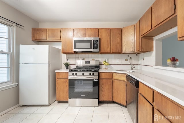 72 Morgan Pl E, Brunswick, NJ 08816 - kitchen with appliances with stainless steel finishes, light countertops, backsplash, and healthy amount of natural light