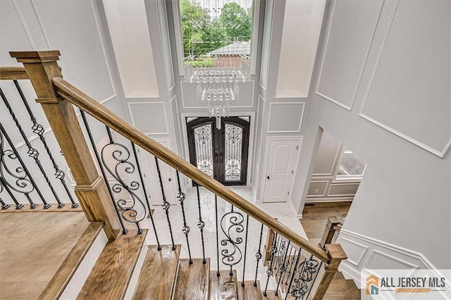 4 Hemlock Dr, Edison, NJ 08820 - stairway featuring a decorative wall, a chandelier, wood finished floors, and french doors