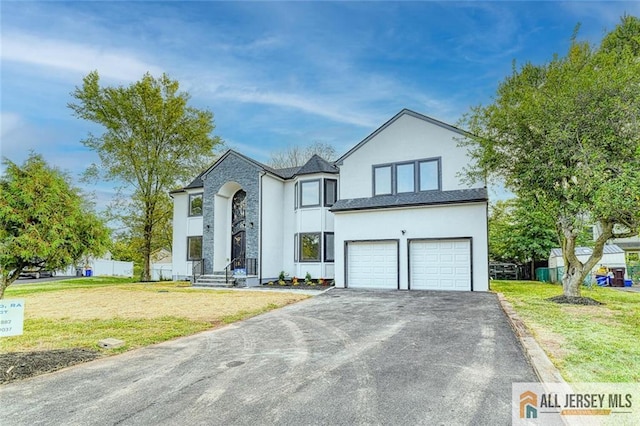 view of front of house with a garage, a front yard, fence, and aphalt driveway