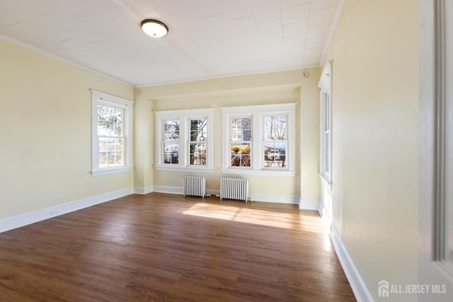 empty room featuring ornamental molding, radiator, and dark wood finished floors