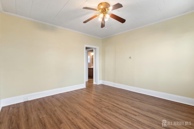 empty room featuring a ceiling fan, crown molding, baseboards, and wood finished floors