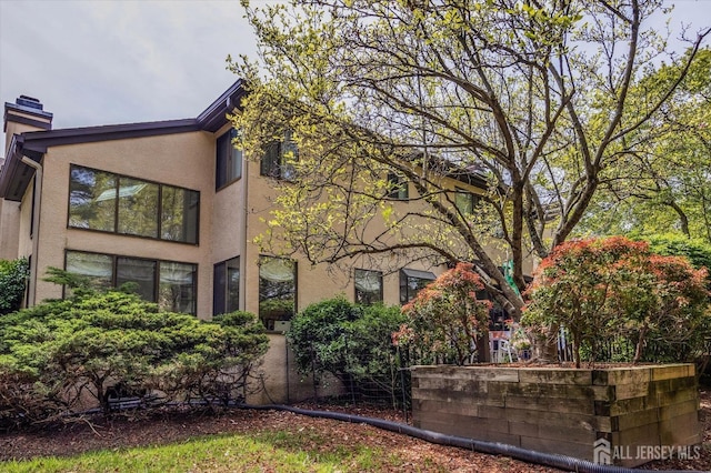 view of property exterior featuring stucco siding and a chimney
