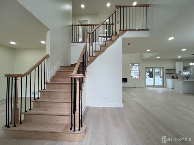 stairs with sink and wood-type flooring