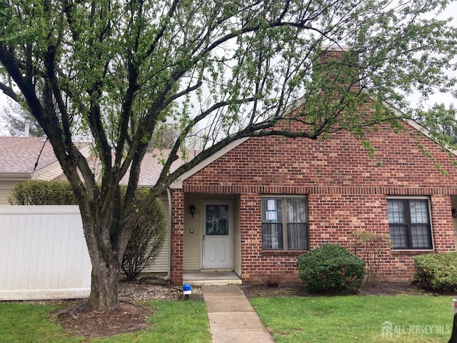 191 Wycoff Way W, East Brunswick, NJ 08816 - view of front of house with a front lawn, brick siding, a chimney, and fence