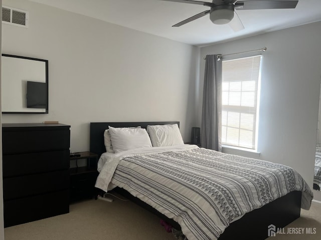 carpeted bedroom with visible vents and ceiling fan