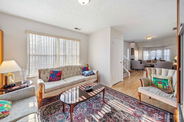 253 Nebula Rd, Piscataway, NJ 08854 - living room featuring a textured ceiling, wood finished floors, and stairway