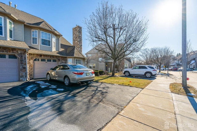 253 Nebula Rd, Piscataway, NJ 08854 - view of home's exterior with asphalt driveway, a chimney, stone siding, a residential view, and a garage