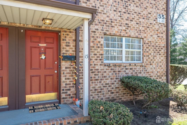 entrance to property featuring brick siding