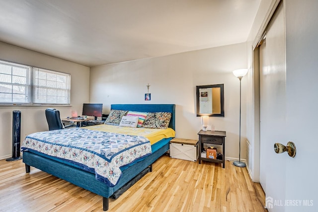 bedroom featuring wood finished floors, a closet, and baseboards