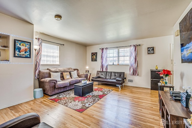 living room with healthy amount of natural light and hardwood / wood-style floors