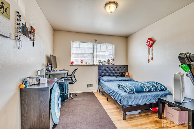bedroom featuring wood finished floors and baseboards