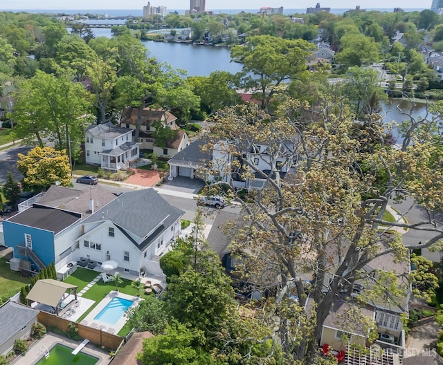 aerial perspective of suburban area with a nearby body of water and a pool area