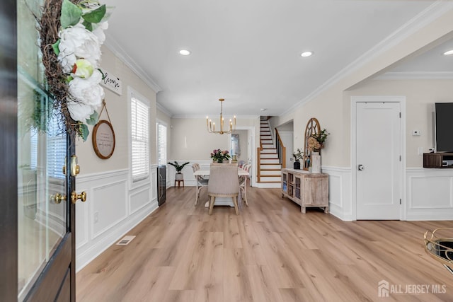 1307 Camp Ave, Ocean, NJ 07712 - dining space featuring stairway, wainscoting, a decorative wall, a chandelier, and light wood-style flooring