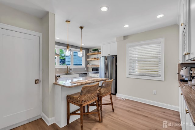 1307 Camp Ave, Ocean, NJ 07712 - kitchen with appliances with stainless steel finishes, a sink, white cabinetry, a peninsula, and light wood finished floors