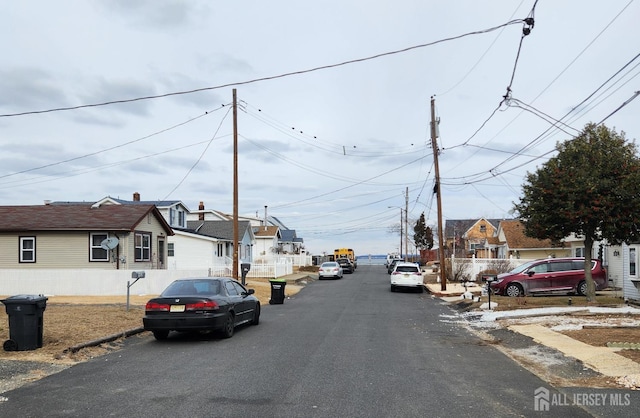 view of road featuring a residential view, curbs, and street lights