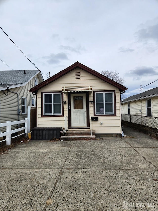 bungalow-style house with entry steps, fence, and driveway