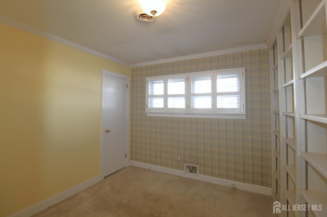 spare room featuring light carpet and crown molding