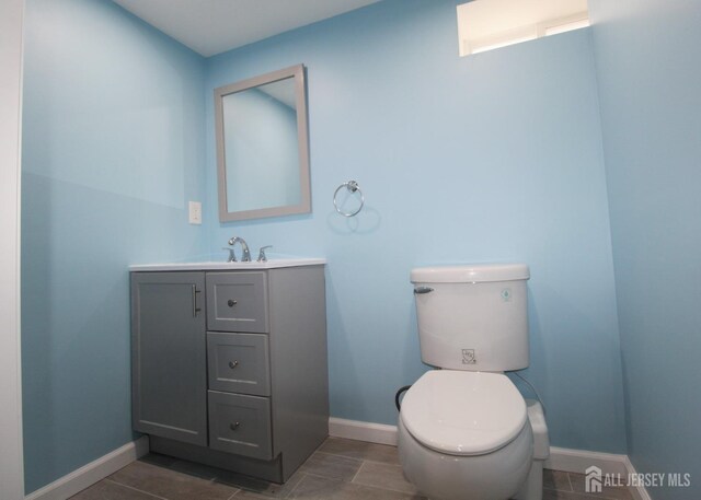 bathroom featuring toilet, vanity, and tile patterned flooring